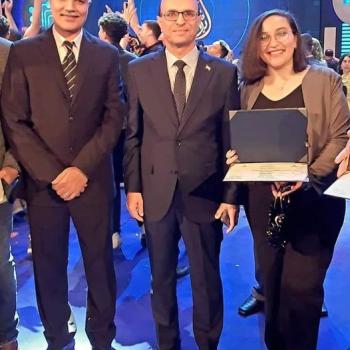 A souvenir photo with Professor Dr. Ahmed El-Menshawy, President of Assiut University, for student Claudia Atef Fayez in the third year - Faculty of Medicine (Cultural Activity Management) after winning and obtaining first place in the field of short stories.